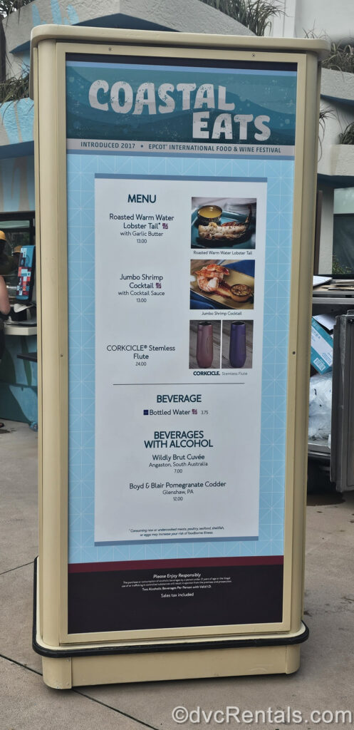 The blue, white, and black menu board for the Coastal Eats book. There are photos and descriptions of the different food and drink options, as well as pricing displayed on the menu board.