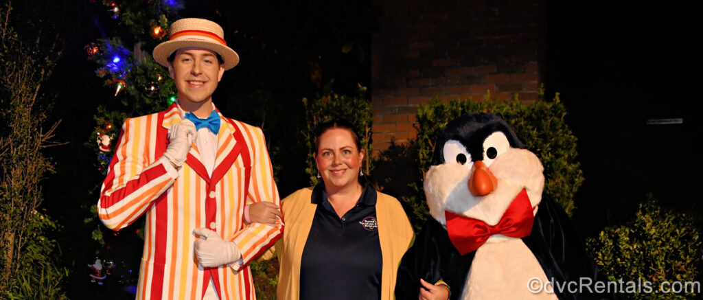 DVCR team member Stacy poses with characters Bert in his red, yellow, and white striped suit and hat and a penguin with a red bow tie from Mary Poppins.