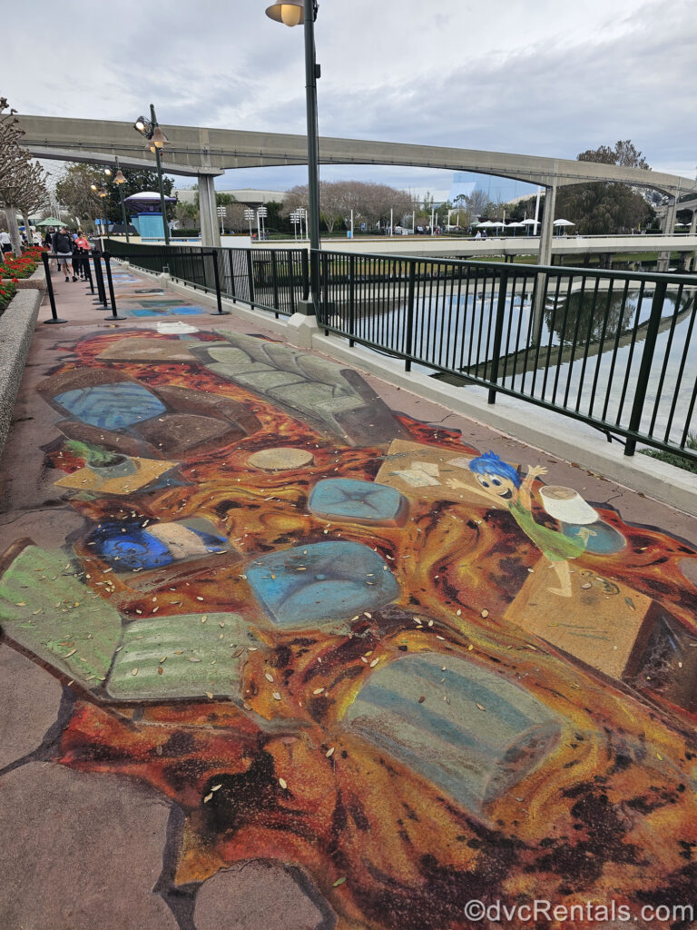 A multicolored art piece depicting characters from Inside Out is seen on a pathway at EPCOT during the International Festival of the Arts in 2024.