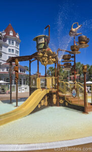 The Alice in Wonderland water play area sprays water under the sun at Disney’s Grand Floridian Resort & Spa.