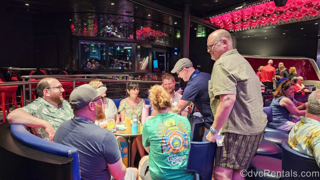 Team members of David’s Vacation Club Rentals mix and mingle, sharing smiles and laughs with guests and DVC owners during an activity onboard the Disney Fantasy.