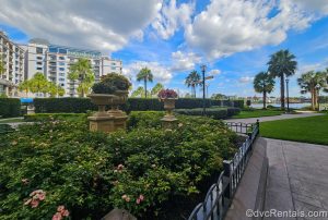 The flower gardens and exterior grounds and buildings of Disney’s Riviera Resort are seen under a blue sky.