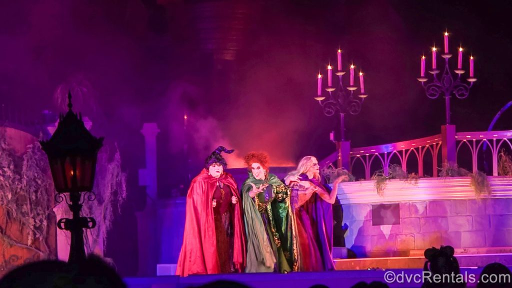 The Sanderson Sisters characters from Hocus Pocus perform on stage at Cinderella Castle during the Hocus Pocus Villain Spelltacular show.