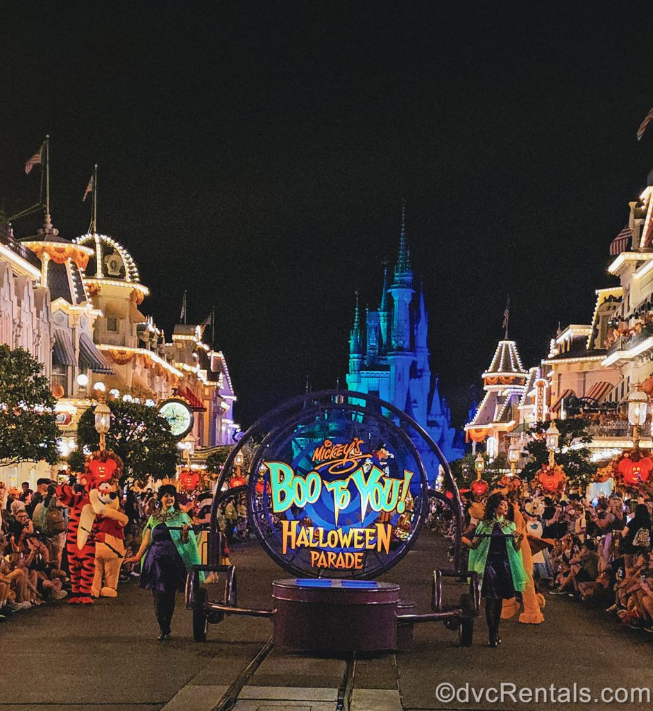 Performers and Disney characters in Halloween costumes get Mickey’s Boo-To-You Halloween Parade started as they make their way down Main Street U.S.A. with Cinderella Castle lit up blue in the background.
