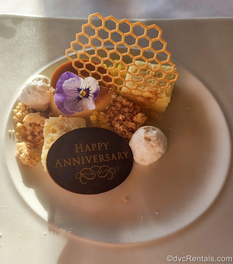 Coconut Flan is served with a “Happy Anniversary” chocolate piece on top at the ‘Ama’Ama – Contemporary Island Cooking at Aulani, a Disney Resort & Spa.