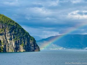 A rainbow shines over the mountainous landscape surrounding the Nordfjord and its waters near Olden, Norway.