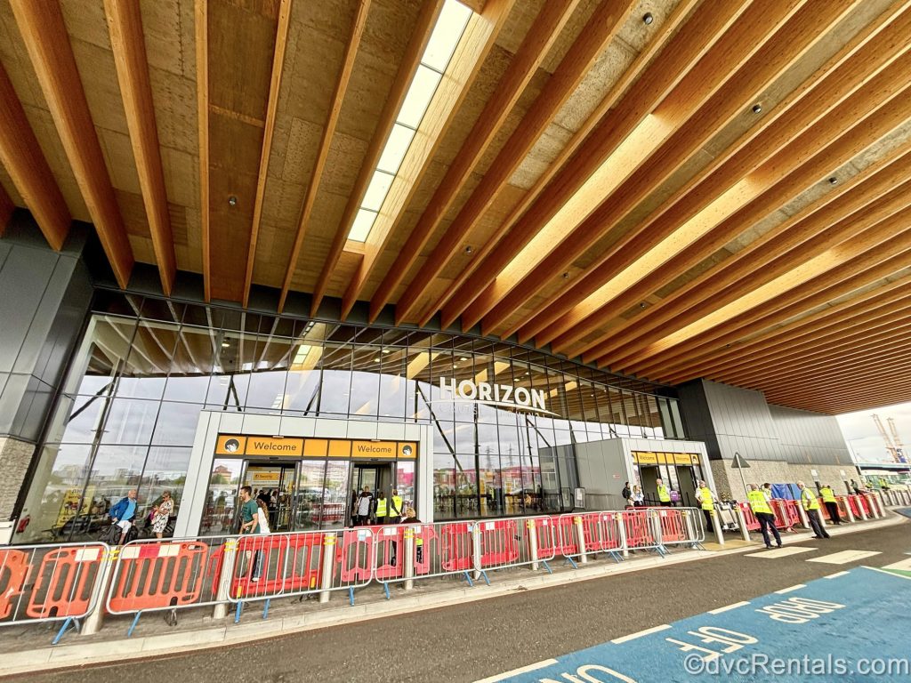 The exterior of the Horizon Cruise Terminal in Southampton, England. Terminal crew and guests are seen outside of the glass doors.