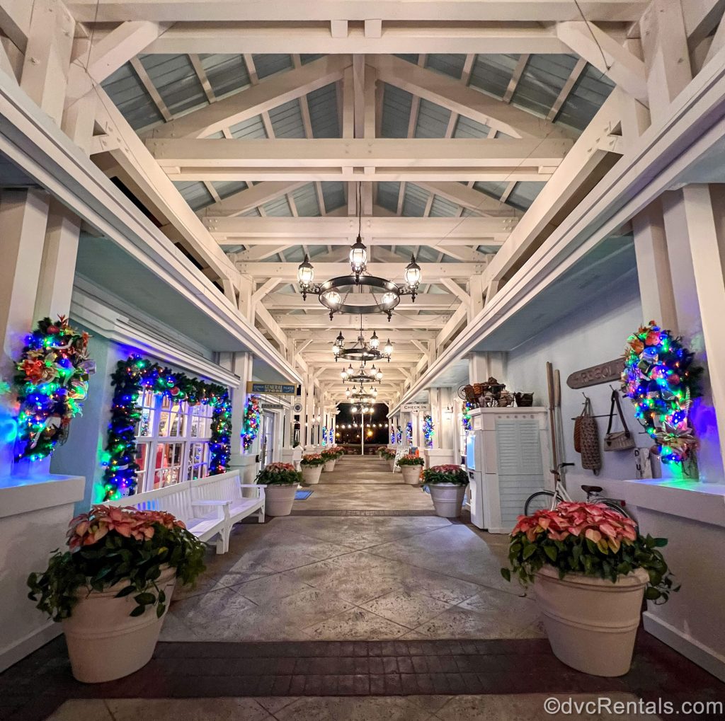 An exterior corridor at Old Key West’s Hospitality House is decorated with colorful Christmas wreaths, garlands, and poinsettia plants in white pots.