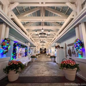 An exterior corridor at Old Key West’s Hospitality House is decorated with colorful Christmas wreaths, garlands, and poinsettia plants in white pots.