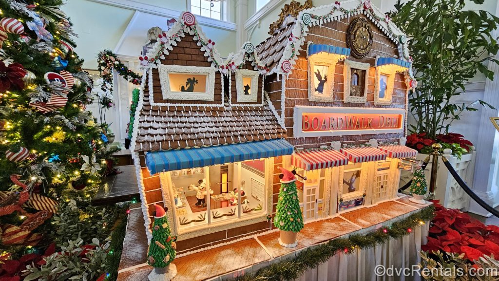 A gingerbread display of the BoardWalk Deli is seen in the lobby of Disney’s BoardWalk Villas along with colorful Christmas trees and garlands.