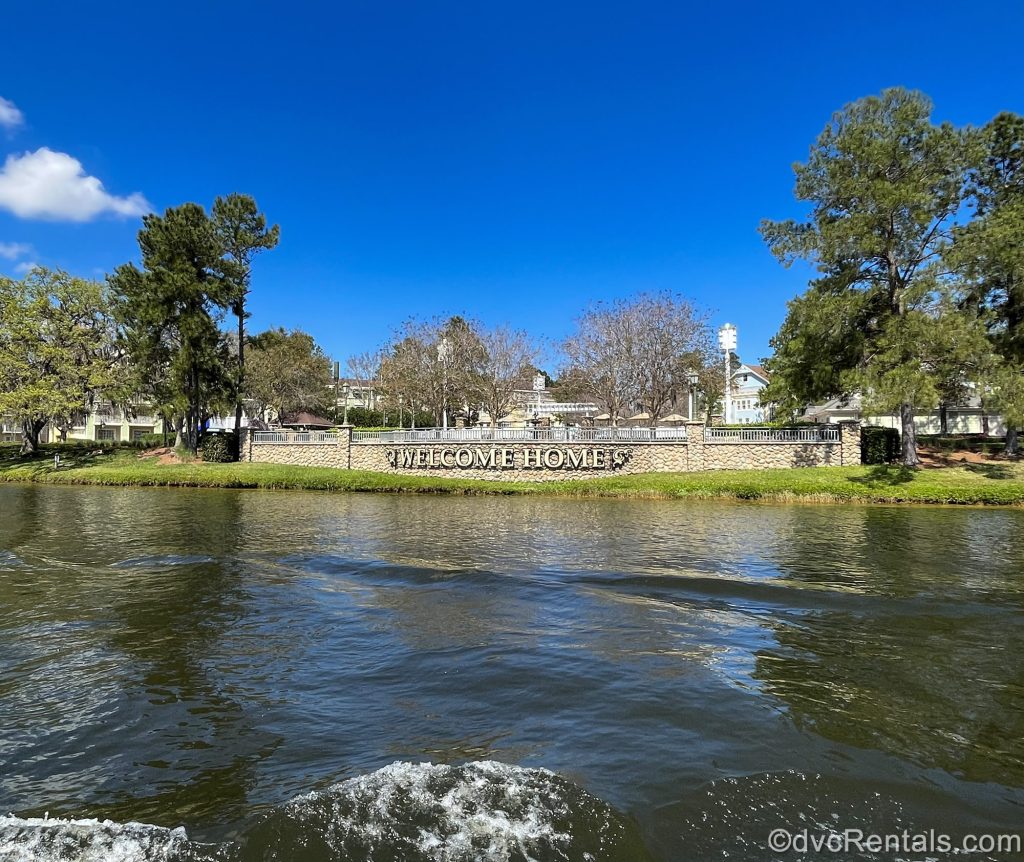 The message “Welcome Home” is displayed along fencing at Disney’s Saratoga Springs Resort & Spa as viewed from the boat heading over the water back to the resort.