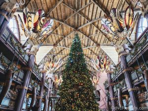 A gigantic Christmas tree decorated with white lights and African-inspired ornaments is displayed in the lobby of Disney’s Animal Kingdom Villas Jambo House. There are matching garlands stung along the balcony railings overlooking the main floor as well.