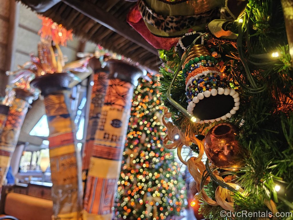 Colorful beaded and handcrafted ornaments are seen displayed on lit trees and garlands at Disney’s Animal Kingdom Villas Kidani Village.