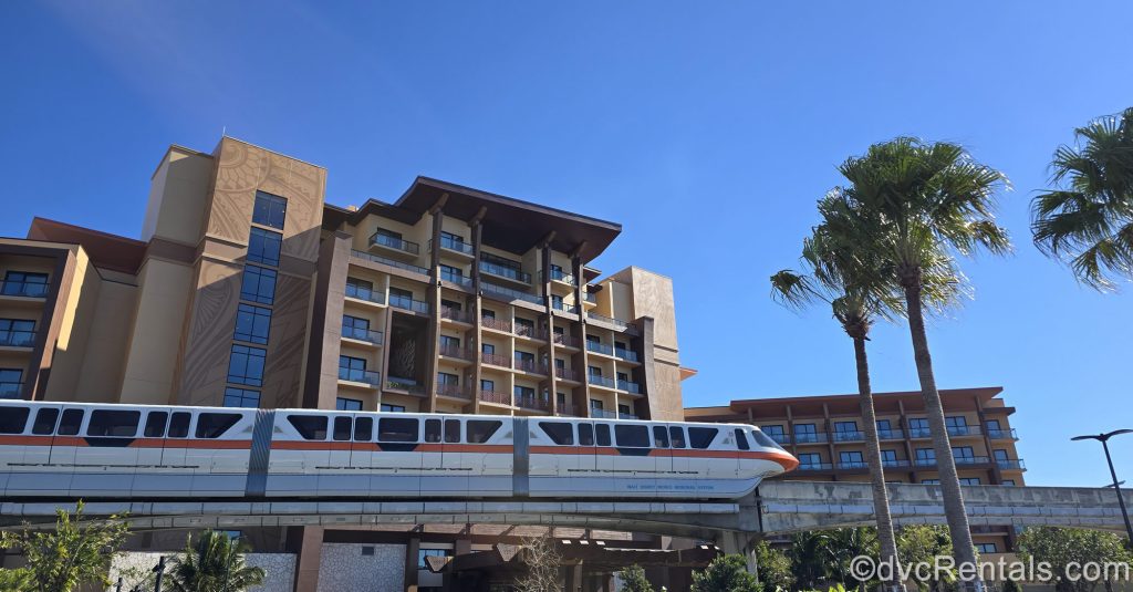 The monorail passes by the Island Tower at Disney’s Polynesian Villas & Bungalows under a sunny sky.