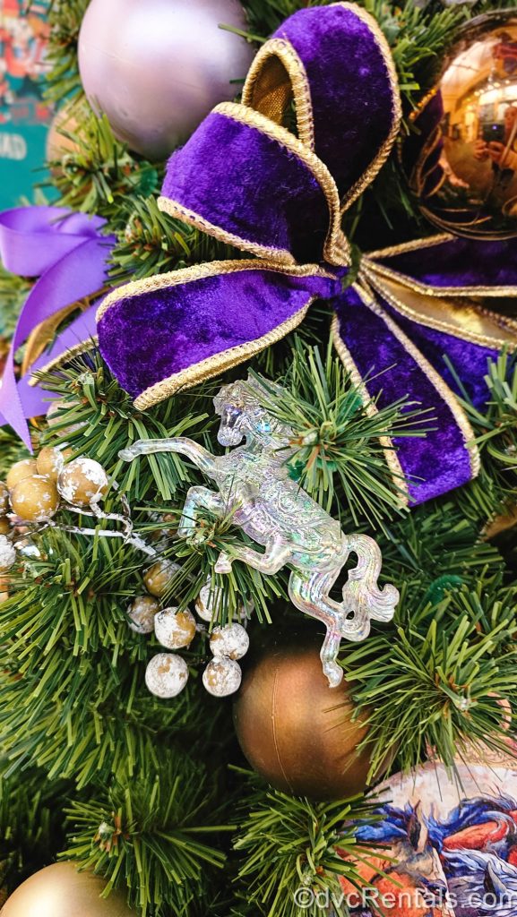 Purple and gold equestrian-themed ornaments and ribbons are displayed in the holiday décor at Disney’s Saratoga Springs Resort & Spa.