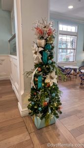 A small Christmas tree decorated with pastel, nautical-themed ornaments is displayed in the lobby of Disney’s Old Key West Resort