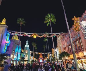 Silver tinsel garlands with sparkling stars and colorful ornaments are hung above the crowds entering Disney Jollywood Nights down Hollywood Boulevard in Disney’s Hollywood Studios Theme Park.