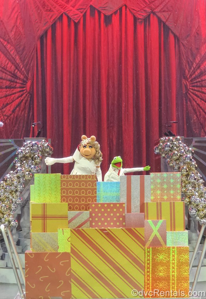 Kermit the Frog and Miss Piggy perform in white holiday-themed costumes during the Disney Holidays in Hollywood show.