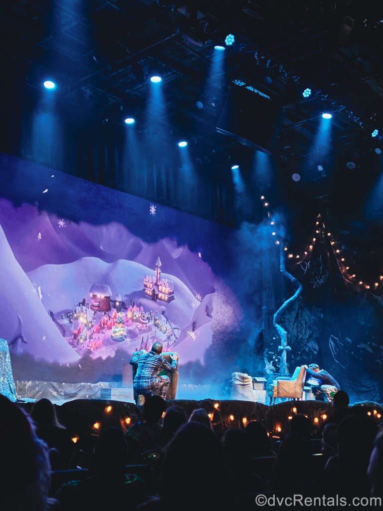 Two performers on stage react to the film clip and song about Christmas traditions playing on-screen during the What’s This? Tim Burton’s The Nightmare Before Christmas Sing Along!