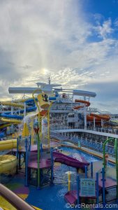 The colorful waterplay area and waterslides onboard the Wonder of the Seas cruise ship are seen under a hazy blue sky.