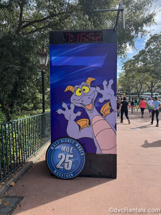 Figment is seen on mile-marker and time signage during a runDisney race event at EPCOT as participants make their way along the event course.