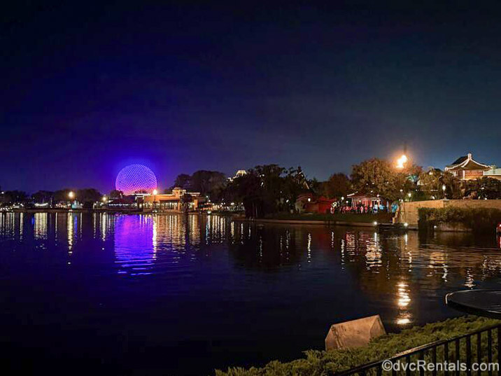 World Showcase Lagoon and Spaceship Earth are seen lit up at night at EPCOT as runners make their way through the park on the race event route.