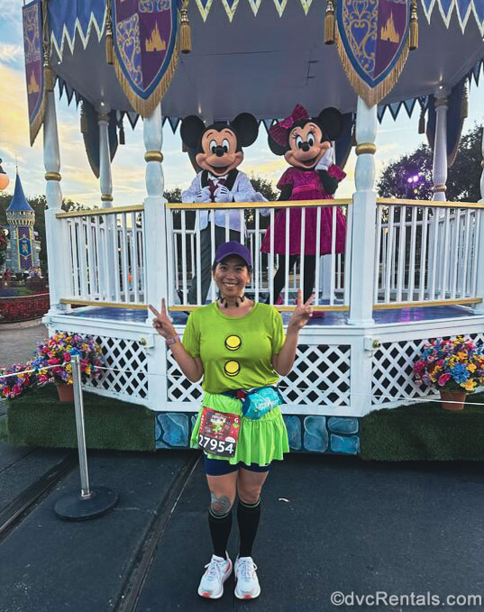 David’s Vacation Club Rentals team member Joanne poses with a smile with Mickey and Minnie Mouse at Magic Kingdom during a runDisney race event.