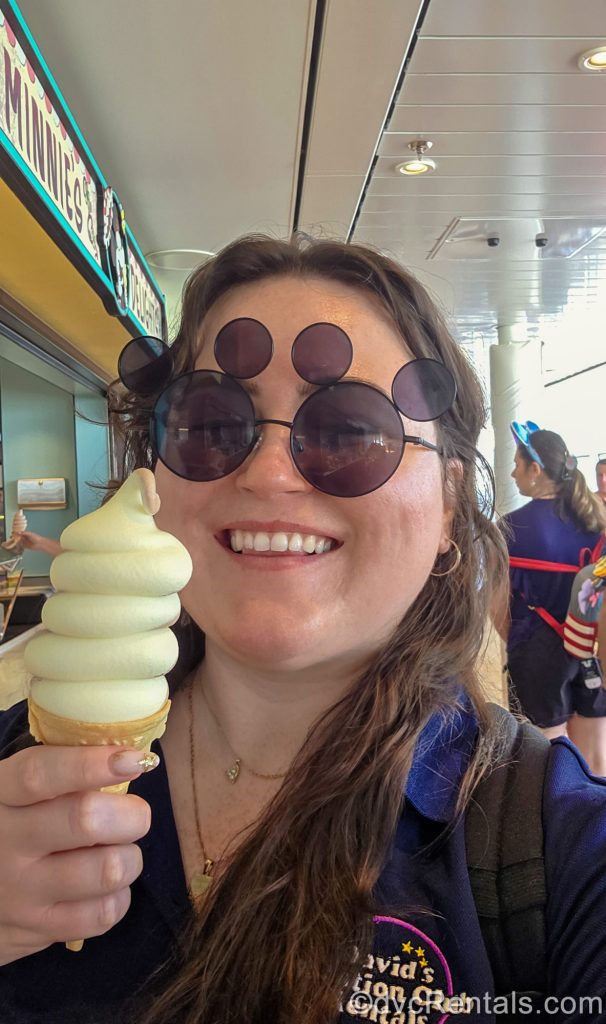 David’s Vacation Club Rentals team member Elyse poses with a big smile and a soft-serve ice cream cone onboard her first Disney Cruise.
