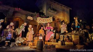 The “auction” scene from the Pirates of the Caribbean attraction at Magic Kingdom. The scene includes several animatronic pirate figures carrying items such as statues, paintings, and other valuables.