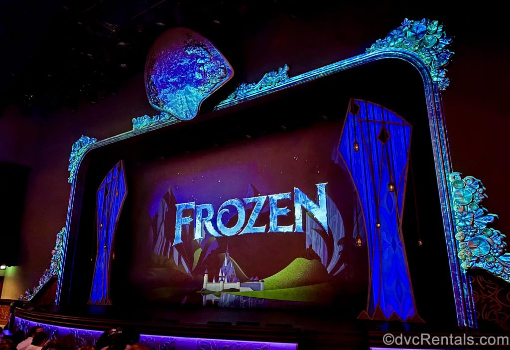 The title “Frozen” is displayed on screen along with a drawing of a white castle as the stage is set for the live production onboard the Disney Destiny.