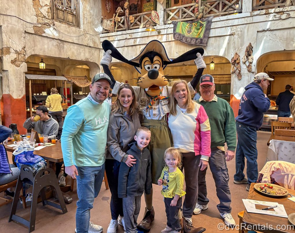 Guest blogger Christie Hecht poses with her family and Goofy at Tusker House at Disney’s Animal Kingdom Theme Park.