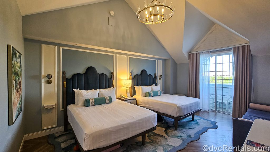 A Resort Studio at the Villas at Disney’s Grand Floridian Resort & Spa. The room features 2 queen beds and is decorated with blue tones and Mary Poppins inspired artwork and accents.