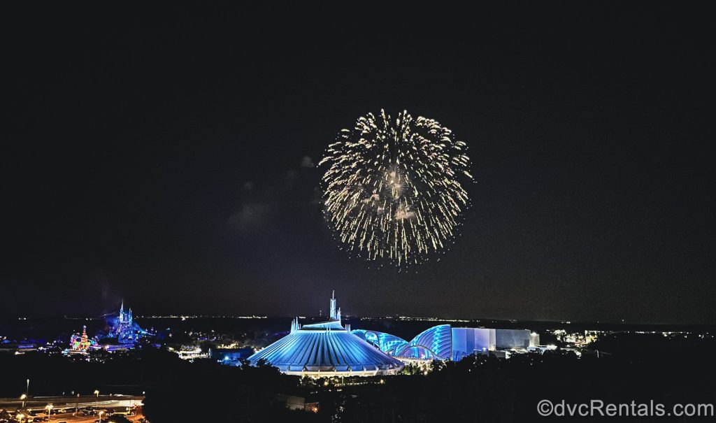 Golden fireworks shimmer in the night sky over the Magic Kingdom as seen from a Villa balcony at Bay Lake Tower at Disney’s Contemporary Resort.