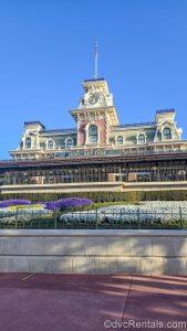 The Train Station stands over the entry way to the Magic Kingdom at Walt Disney World under a sunny, blue sky.