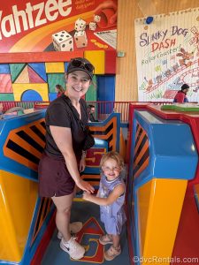 Guest blogger Christie Hect poses with her youngest child while waiting to ride Slinky Dog Dash at Disney’s Hollywood Studios Theme Park.