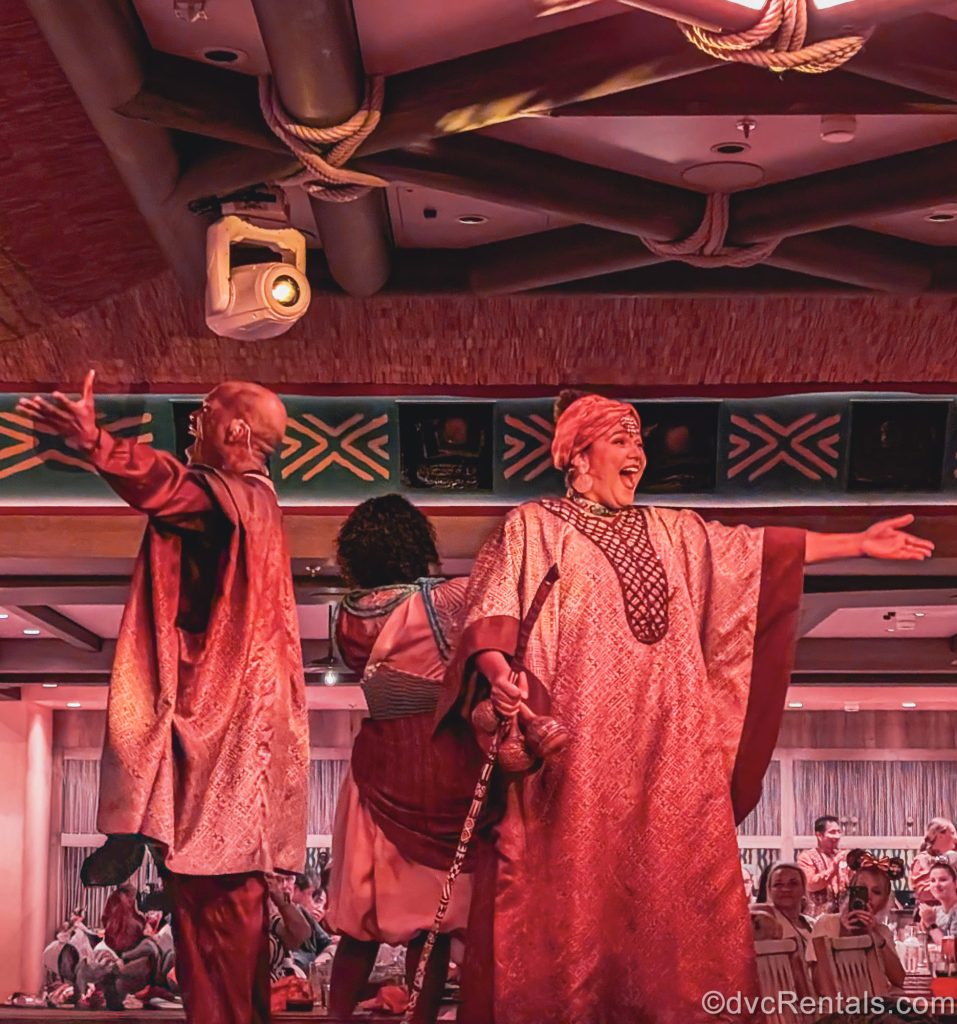 Performers in African-themed costumes perform songs from The Lion King during dinner in the Pridelands: Feast of the Lion King dining room.