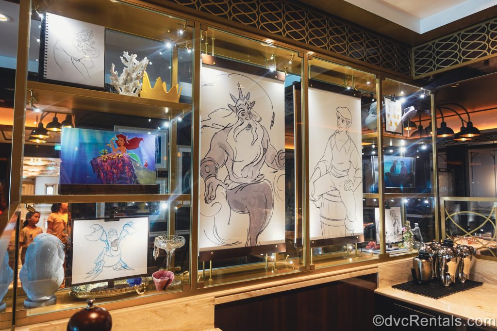 Concept art, drawings, and models from The Little Mermaid are seen on display in the 1923 dining room onboard the Disney Destiny.