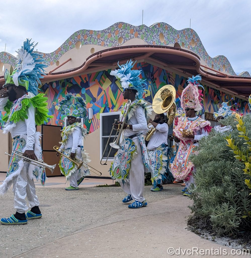 Musicians perform with instruments at Disney Lookout Cay at Lighthouse Point in colorful Bahamian costumes.