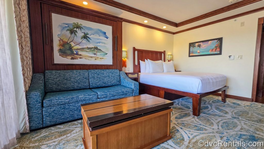 A Deluxe Studio at Disney’s Polynesian Villas & Bungalows. The Studio is decorated with dark woods, and island-inspired Disney artwork from films like Moana and Lilo & Stitch.