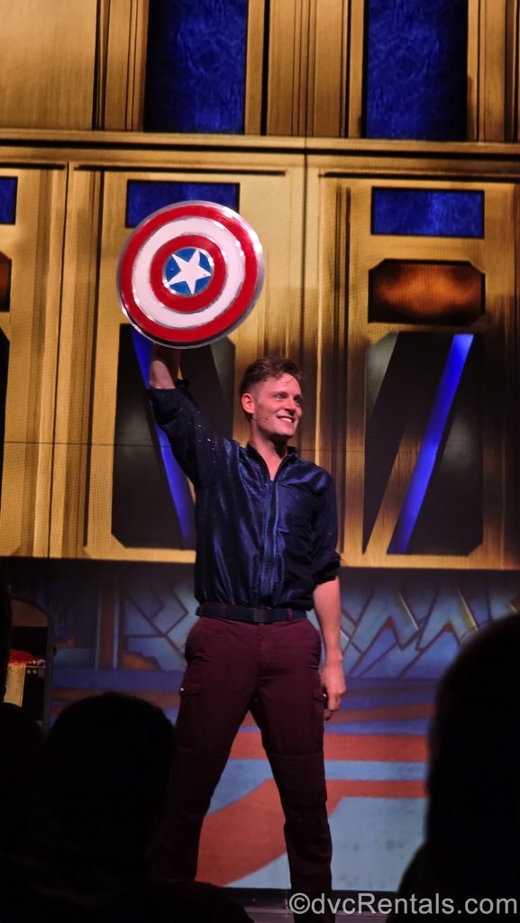 A Disney Cruise Line performer holds up Captain America’s shield during a comedy show performance on the Disney Destiny.
