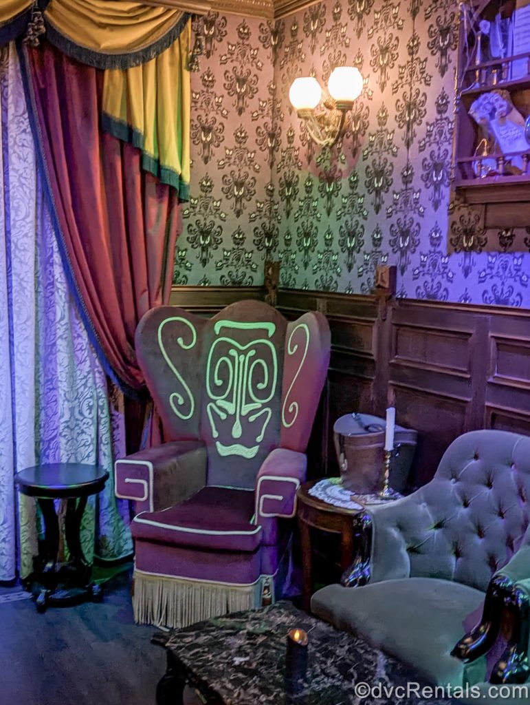 Haunted Mansion-inspired seating and décor as well as the infamous purple wallpaper from the Disney Parks attraction is seen in the Haunted Mansion Parlor onboard the Disney Destiny cruise ship.