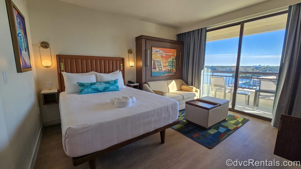 A Deluxe Studio at Bay Lake Tower at Disney’s Contemporary Resort. The room is decorated with neutral tones and brightly colored retro-style art depicting Disney resorts and park attractions.