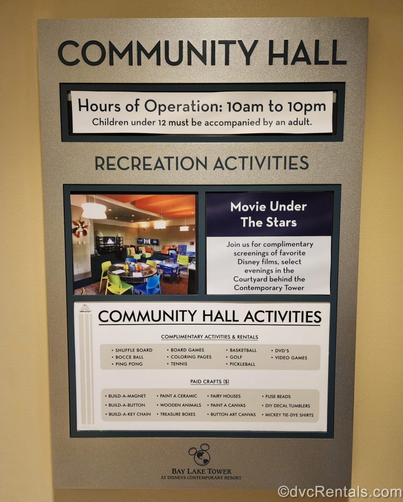 A sign displaying activity information and operational hours for the Community Hall at Bay Lake Tower is seen.