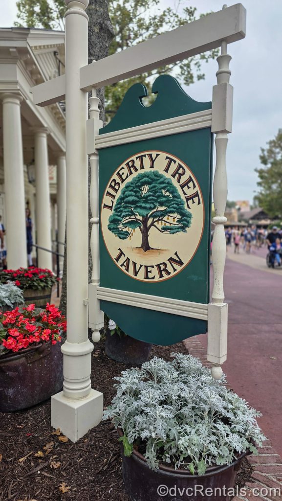 A white and green wooden sign for Liberty Tree Tavern restaurant is seen in Liberty Square at Walt Disney World’s Magic Kingdom.