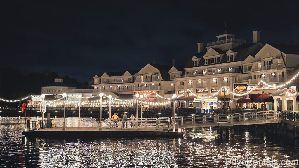 Warm lights illuminate the Boardwalk and shimmer over Crescent Lake as guests enjoy an evening of shopping, dining, and entertainment at the resort.