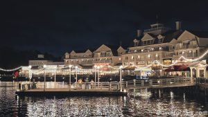 Warm lights illuminate the Boardwalk and shimmer over Crescent Lake as guests enjoy an evening of shopping, dining, and entertainment at the resort.