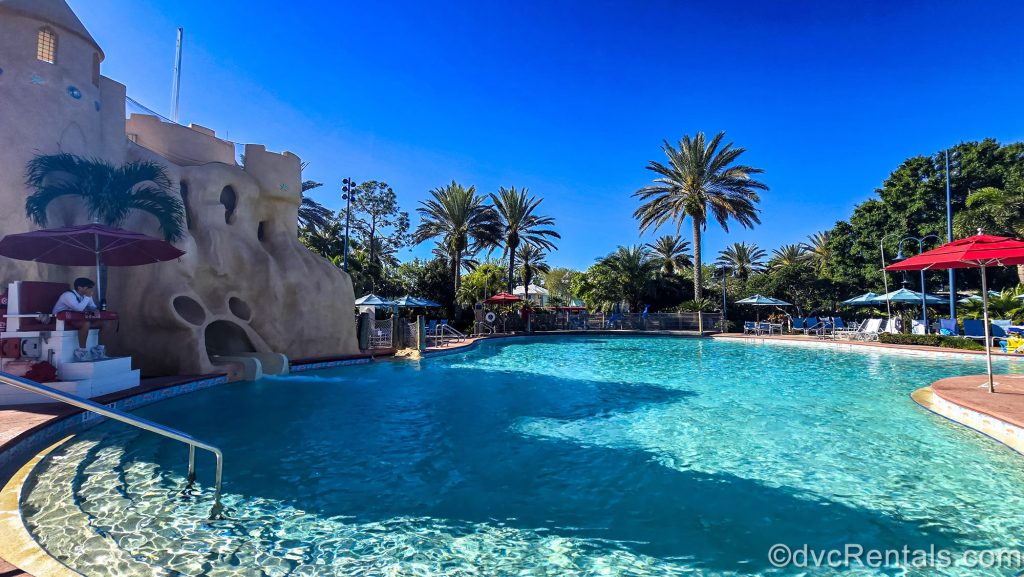The Sandcastle Pool along with the lifeguard on duty and Mickey-shaped waterslide entry into the pool is seen under a bright, blue sky at Disney’s Old Key West Resort.