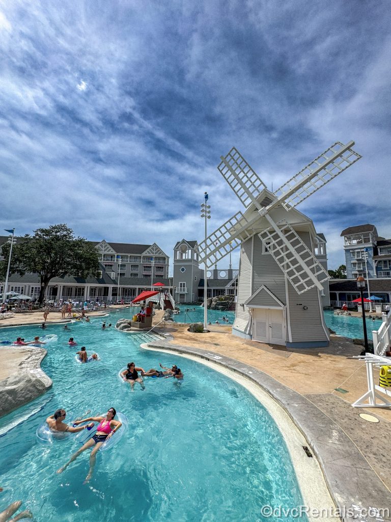 Guests float and swim in the sunshine in the lazy river and pool of Stormalong Bay at Disney’s Beach Club Villas.