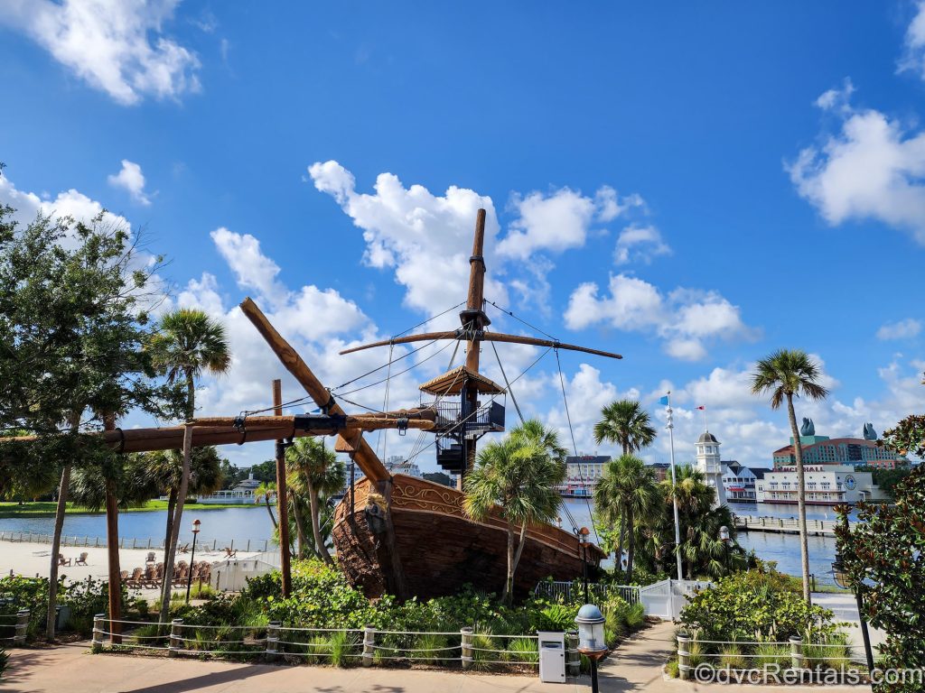 The life-size shipwreck replica waterslide is seen under a blue sky at Disney’s Beach Club Villas next to Crescent Lake.