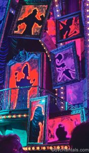 Silhouettes of Disney Villains such as Jafar, Yzma, and more are seen in the stage design of the Villains Unfairly Ever After show, lit with shades of red, purple, and green.